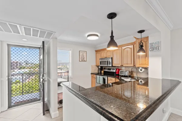 a view of a kitchen with kitchen island a counter top space and stainless steel appliances
