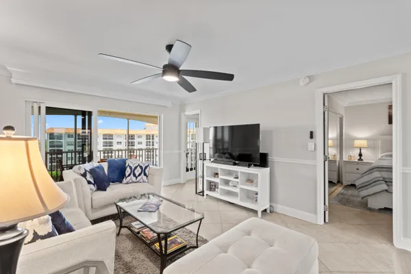 a living room with furniture a flat screen tv and a large window