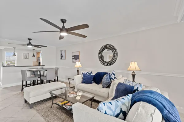 a living room with furniture a clock and a ceiling fan