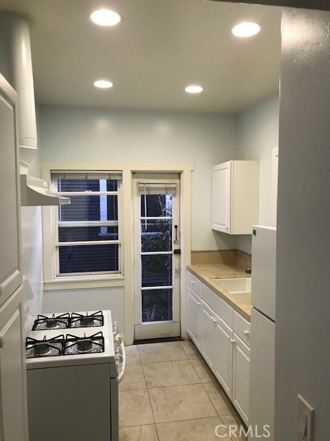 1025 Locust Avenue Long Beach, CA 90813 - Photo 32 of 64 a kitchen with stainless steel appliances granite countertop a stove and a refrigerator