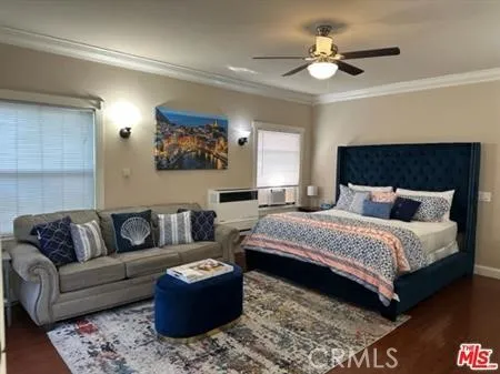 a bedroom with a bed a flat screen tv and a couch