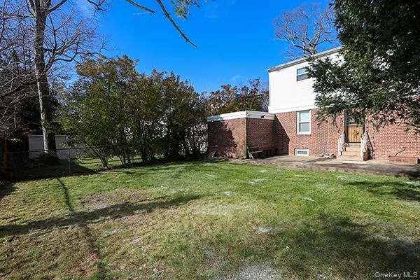 a view of a backyard with potted plants and large trees