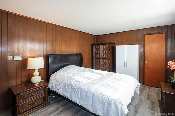 a bedroom with a bed and dresser with mirror