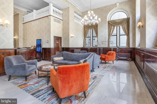 a living room with furniture a large window and a chandelier
