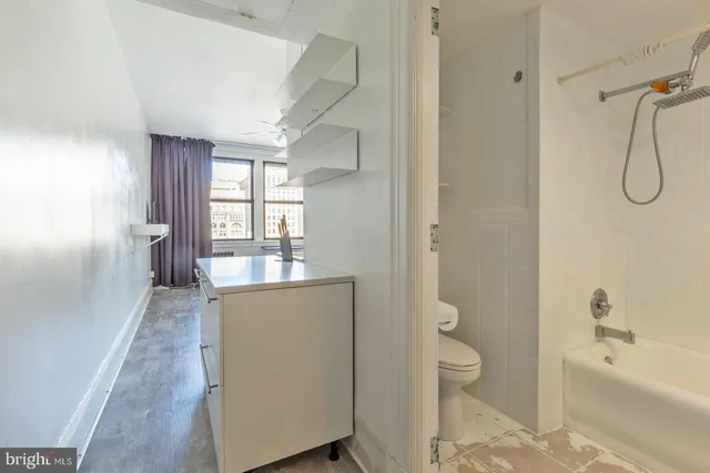 a bathroom with a granite countertop sink a toilet and shower