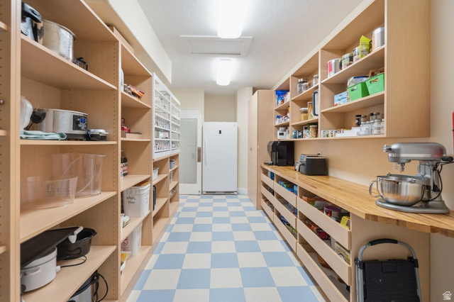 672 Perry Hollow Drive Mapleton, UT 84664 - Photo 33 of 106 Dedicated pantry room featuring extensive built-in shelving, wood-finish countertops, and checkerboard floor tiling