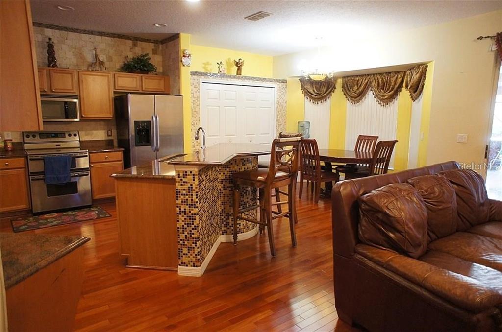 5948 Winchester Isle Road Orlando, FL 32829 - Photo 7 of 23 a living room with furniture and wooden floor