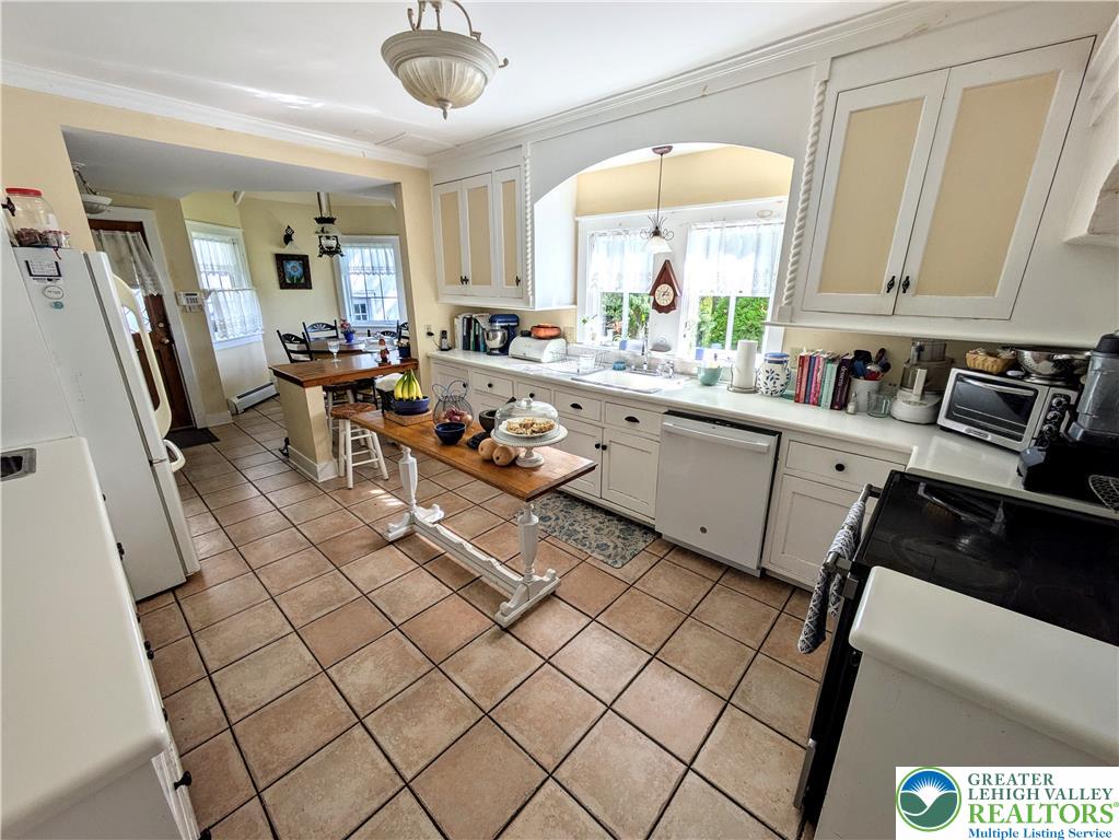 1731 Howell Road Easton, PA 18040 - Photo 10 of 60 Classic cabinetry and durable tile flooring highlight this sunlit kitchen space.