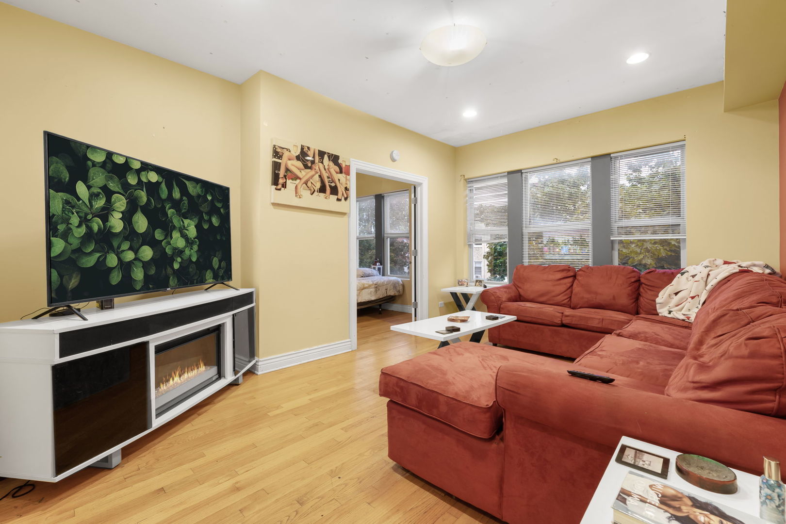 12 North Mayfield Avenue, Unit 3N Chicago, IL 60644 - Photo 3 of 8 a living room with furniture a flat screen tv and a fireplace