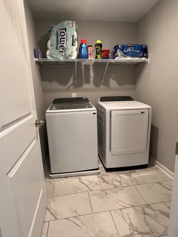a view of washer and dryer with kitchen in the background