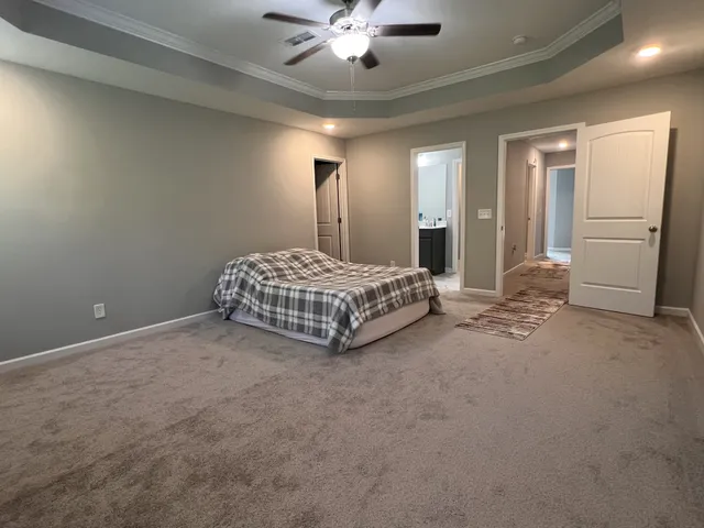 a spacious bedroom with a bed and a chandelier