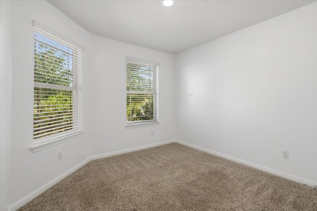 Carpeted spare room featuring baseboards