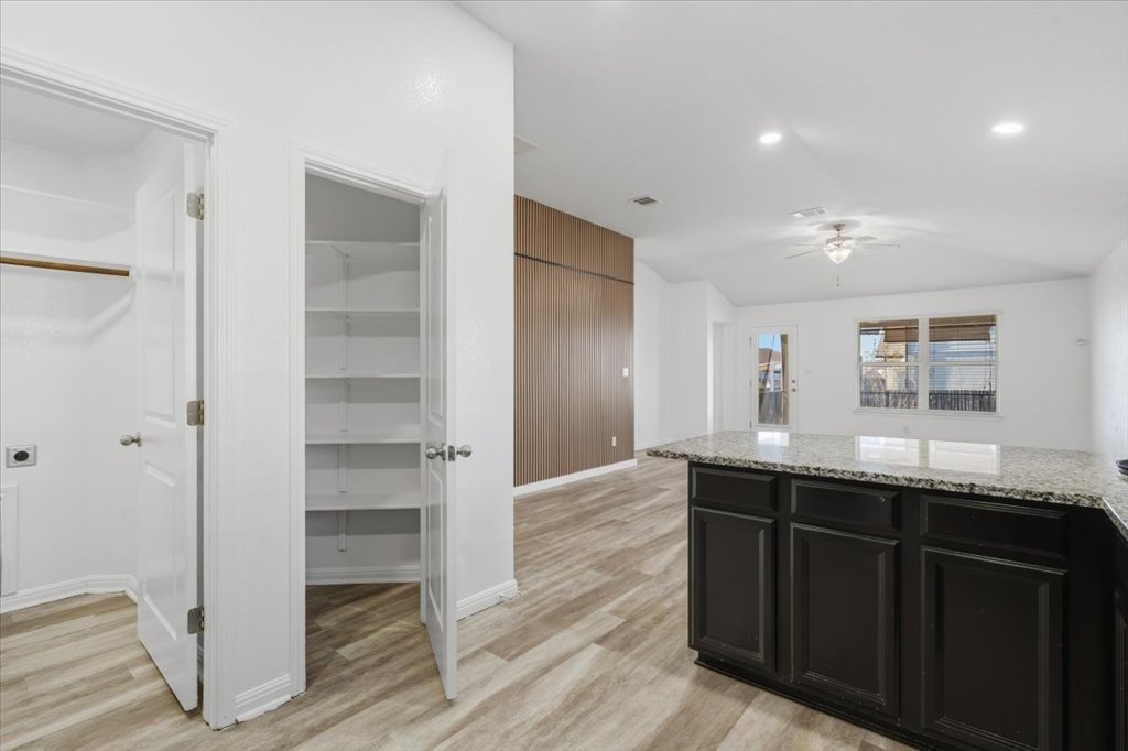 19040 Kimberlite Drive Pflugerville, TX 78660 - Photo 16 of 40 Kitchen featuring dark cabinets, light stone countertops, light wood-style flooring, a ceiling fan, and recessed lighting