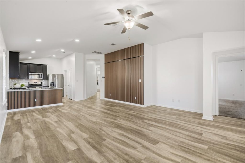 19040 Kimberlite Drive Pflugerville, TX 78660 - Photo 21 of 40 Unfurnished living room featuring lofted ceiling, a ceiling fan, light wood-style flooring, and recessed lighting