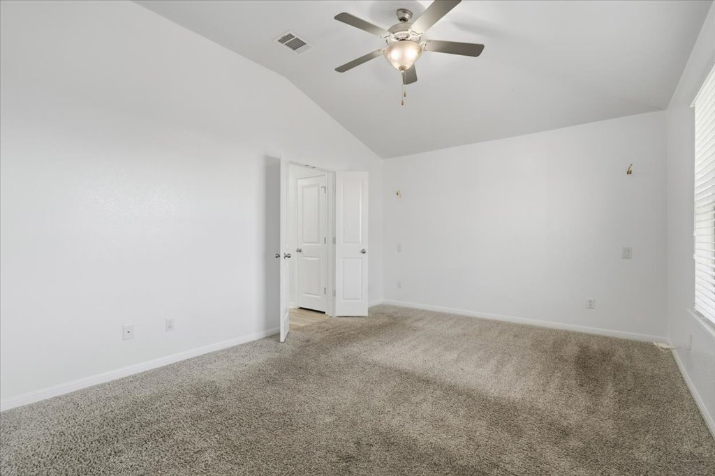 19040 Kimberlite Drive Pflugerville, TX 78660 - Photo 25 of 40 Empty room featuring lofted ceiling, carpet floors, and a ceiling fan