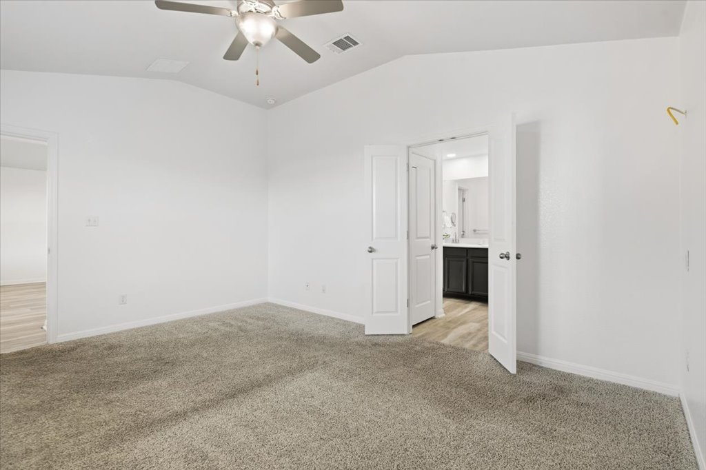 19040 Kimberlite Drive Pflugerville, TX 78660 - Photo 26 of 40 Empty room featuring light carpet, vaulted ceiling, and ceiling fan