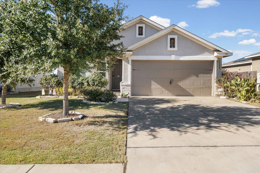 19040 Kimberlite Drive Pflugerville, TX 78660 - Photo 6 of 40 View of front facade with stucco siding, a front yard, driveway, and an attached garage