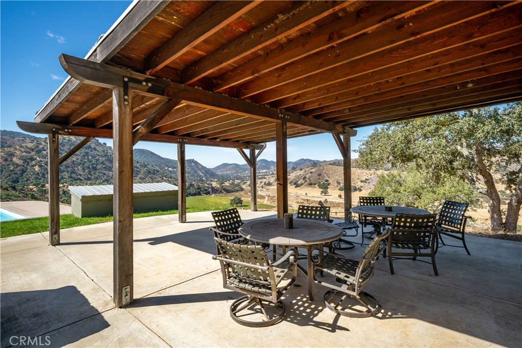 8680 Alamo Creek Road Santa Maria, CA 93454 - Photo 32 of 74 a view of a patio with table and chairs and couches with wooden floor and fence