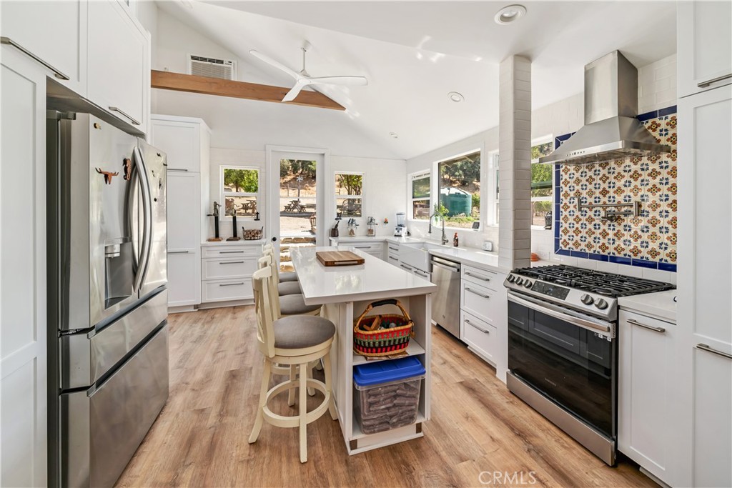 8680 Alamo Creek Road Santa Maria, CA 93454 - Photo 51 of 74 a kitchen with stainless steel appliances a stove a sink dishwasher a refrigerator white cabinets and wooden floor