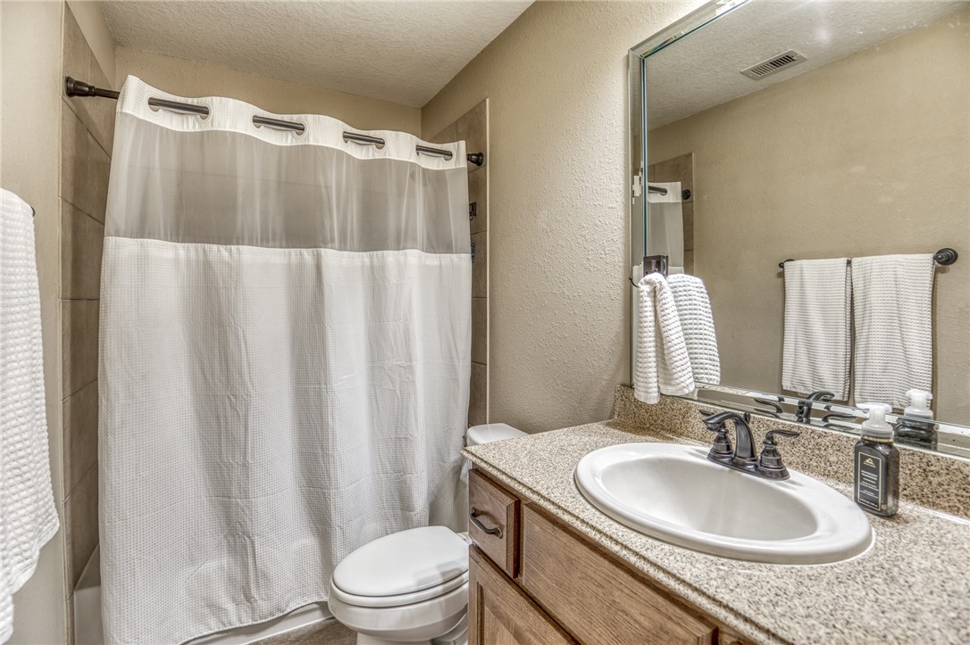 586 Ruby Drive Bellville, TX 77418 - Photo 24 of 50 a bathroom with a granite countertop sink toilet and a mirror