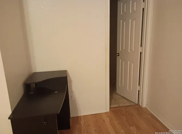 a view of a room with wooden floor and a window