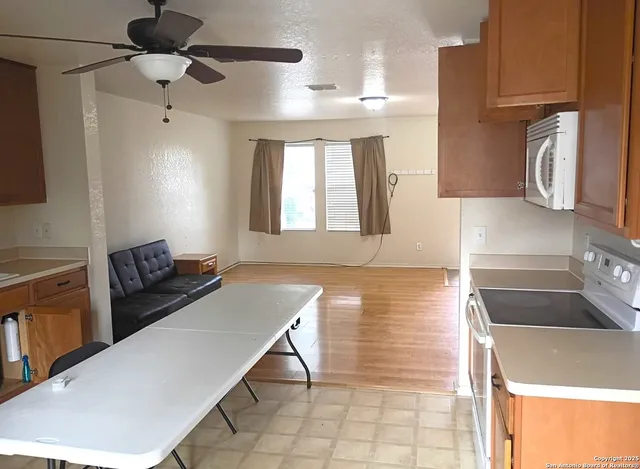 a kitchen with granite countertop a stove a sink and a refrigerator