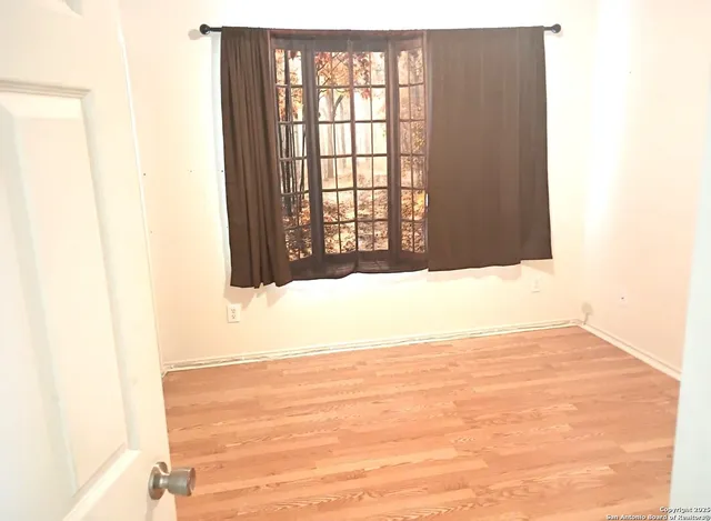 a view of an empty room with wooden floor