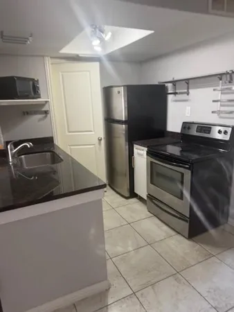 a kitchen with granite countertop a sink and a stove top oven