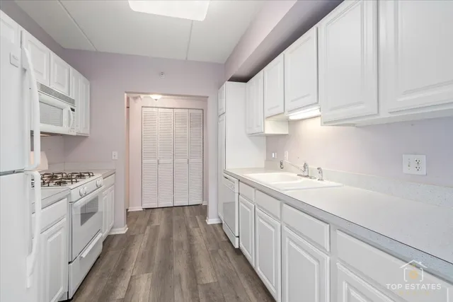 a kitchen with granite countertop a sink stove and cabinets