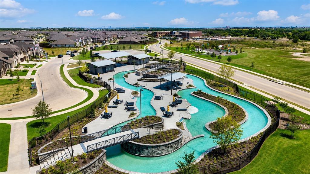 16936 Post Cedar Drive Justin, TX 76247 - Photo 25 of 30 Expansive community amenity featuring a meandering lazy river, multiple covered lounge areas, surrounding paved patios, and a pedestrian bridge