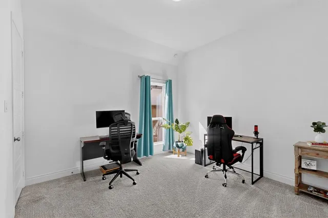 a view of a workspace with furniture and a window