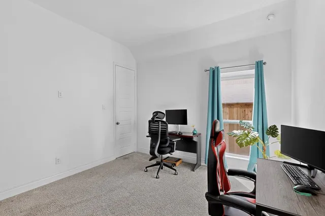 a view of a workspace with furniture and a window