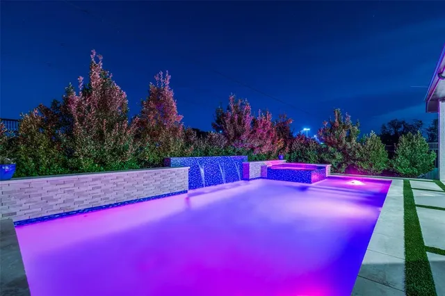 a view of a red building with swimming pool and red chairs