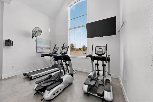 a room with gym equipment and a flat screen tv