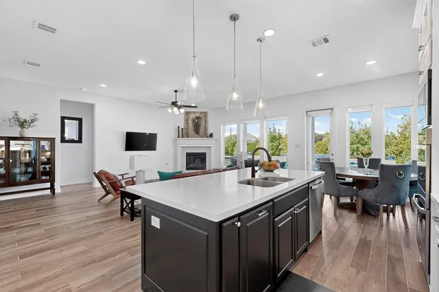 a kitchen with a dining table chairs wooden floor and appliances