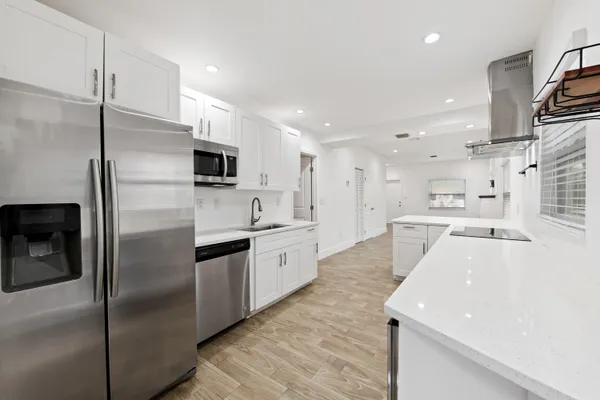 a large kitchen with stainless steel appliances kitchen island a refrigerator sink and cabinets