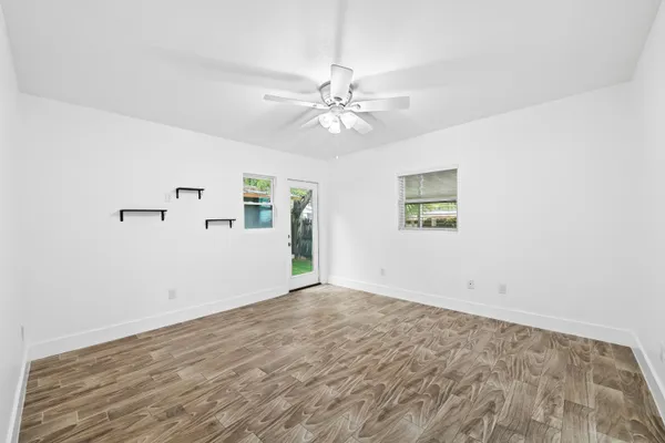 an empty room with fan and windows