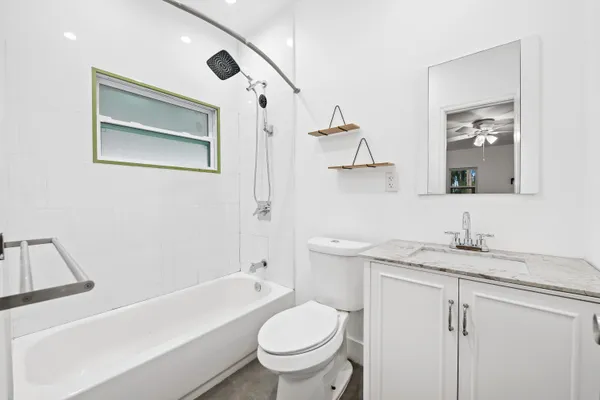 a bathroom with a granite countertop sink toilet and shower