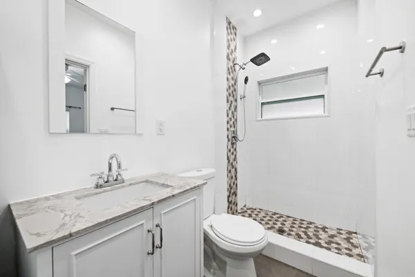 a bathroom with a granite countertop sink toilet and shower