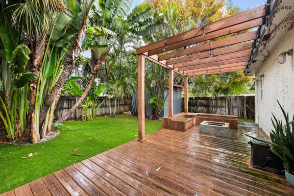 a view of a patio with table and chairs potted plants and large tree