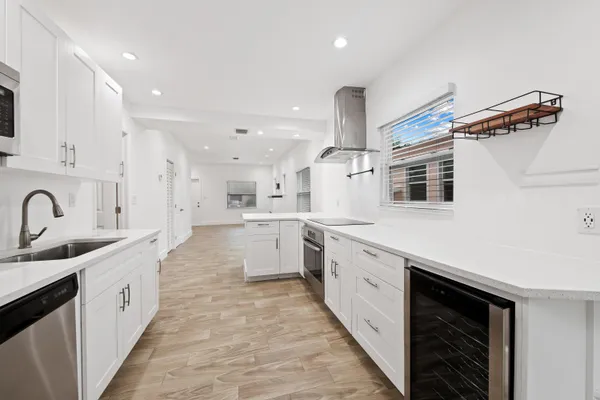 a large white kitchen with stainless steel appliances