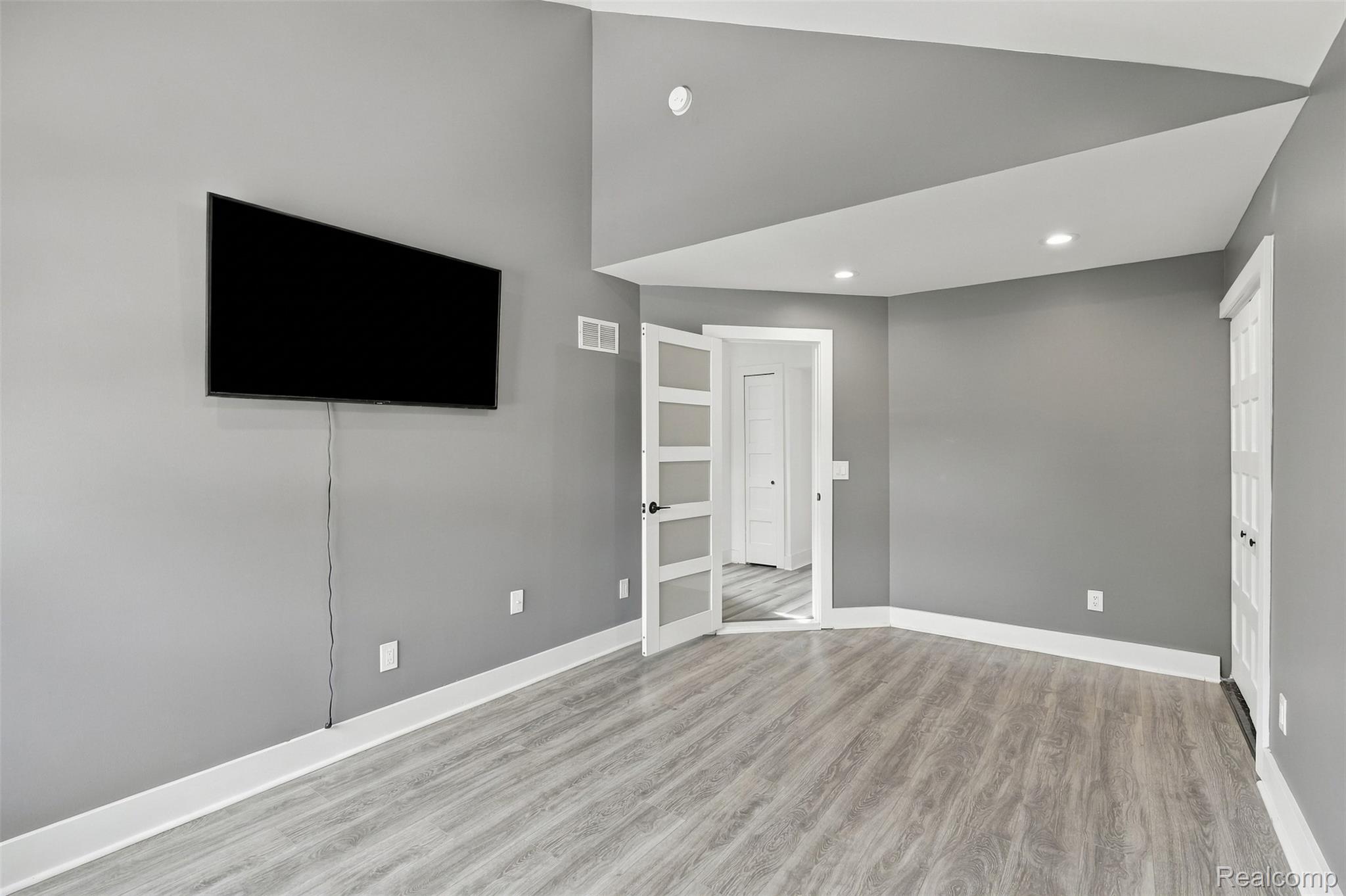 27507 Bell Road Southfield, MI 48034 - Photo 28 of 81 Wood-finish flooring with crisp white baseboards, recessed lighting, and a vaulted ceiling