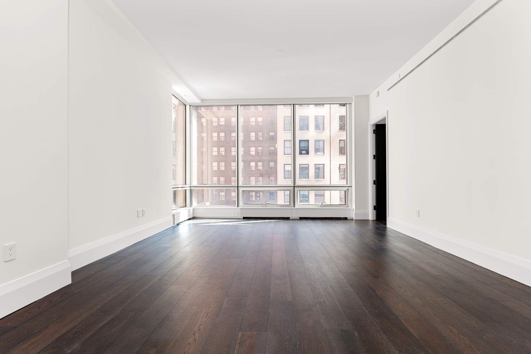 172 Madison Avenue, Unit 8B Manhattan, NY 10016 - Photo 1 of 11 an empty room with wooden floor and windows