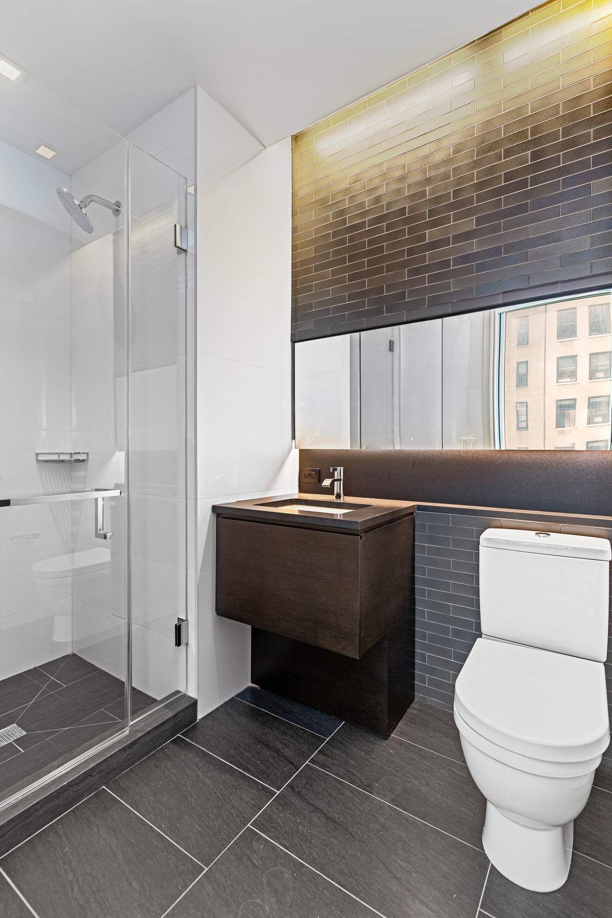 172 Madison Avenue, Unit 8B Manhattan, NY 10016 - Photo 7 of 11 a bathroom with a toilet a sink and shower