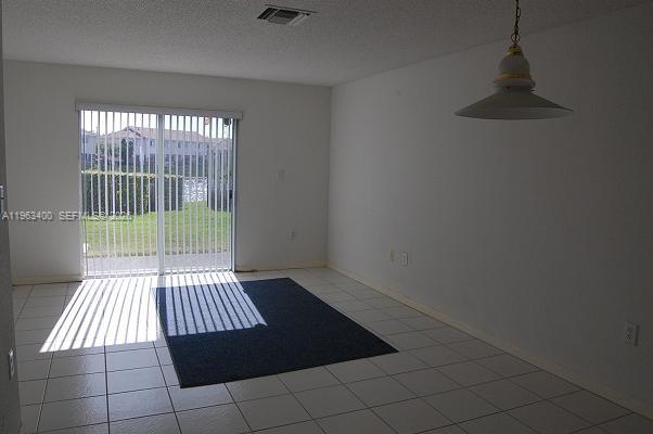 14057 Southwest 121st Place, Unit 724 Miami, FL 33186 - Photo 3 of 9 an empty room with wooden floor and windows