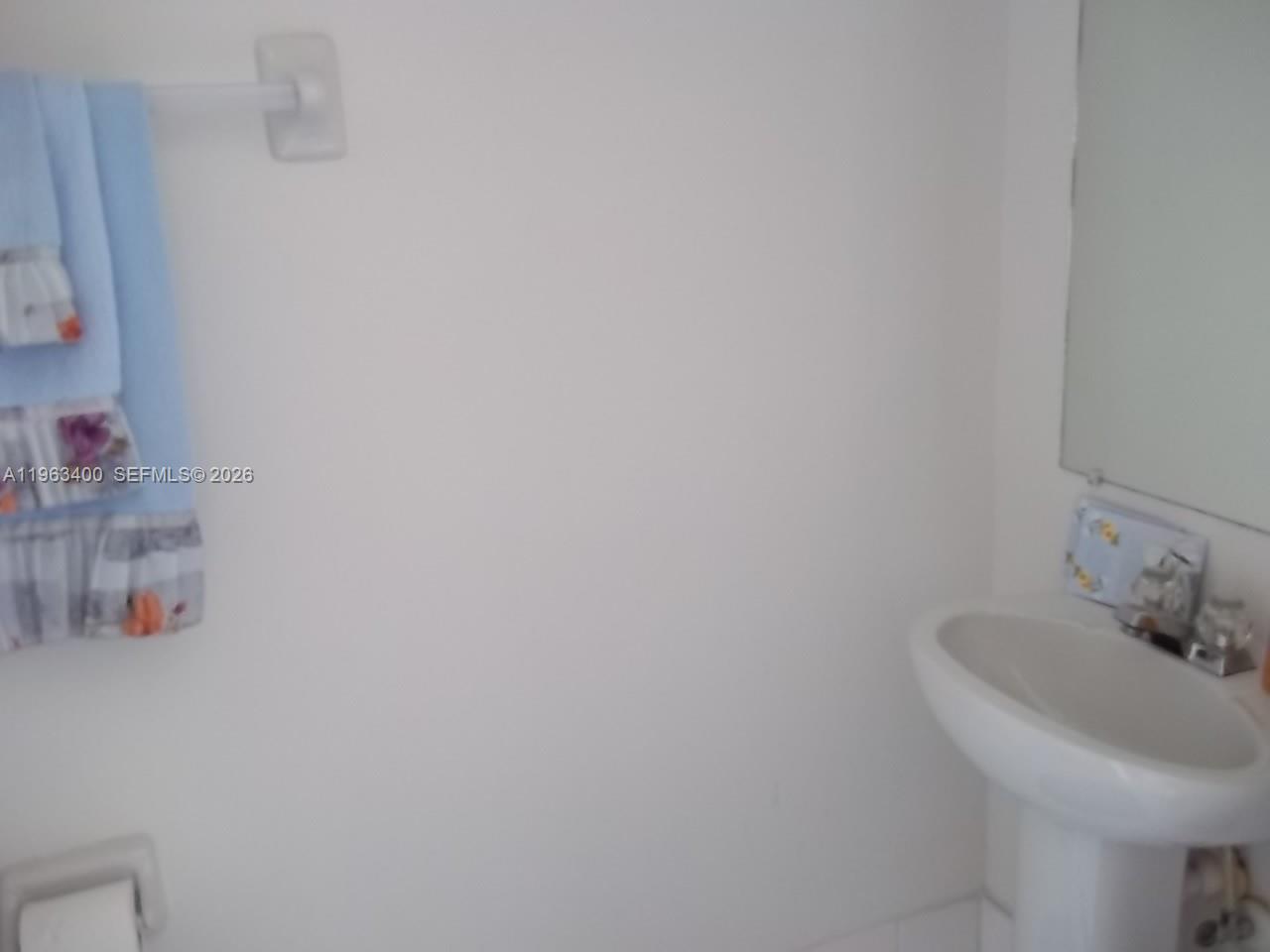 14057 Southwest 121st Place, Unit 724 Miami, FL 33186 - Photo 9 of 9 a bathroom with a sink and a mirror