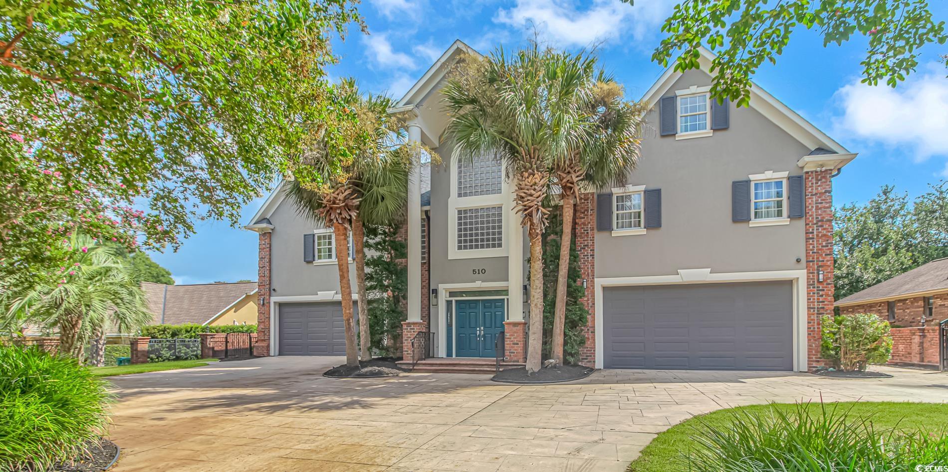 View of front of home with stucco siding, a garage, and driveway