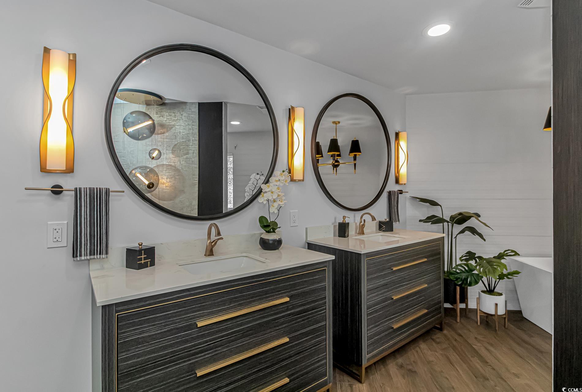 510 Rum Gully Road Murrells Inlet, SC 29576 - Photo 21 of 35 Bathroom with two vanities, wood finished floors, and a freestanding tub