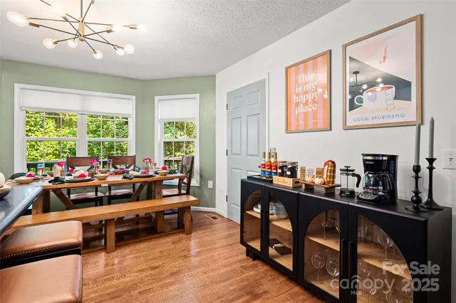 a kitchen with a sink dishwasher a stove and white cabinets with wooden floor