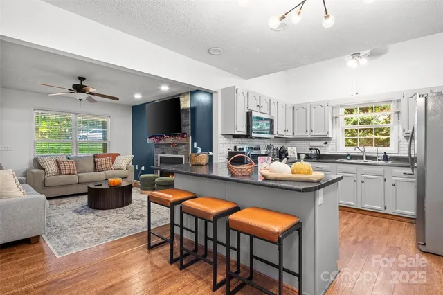 a kitchen with granite countertop white cabinets appliances and a window